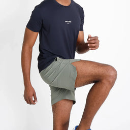 Short VISTORR verde militar com fenda lateral destacada durante exercício.