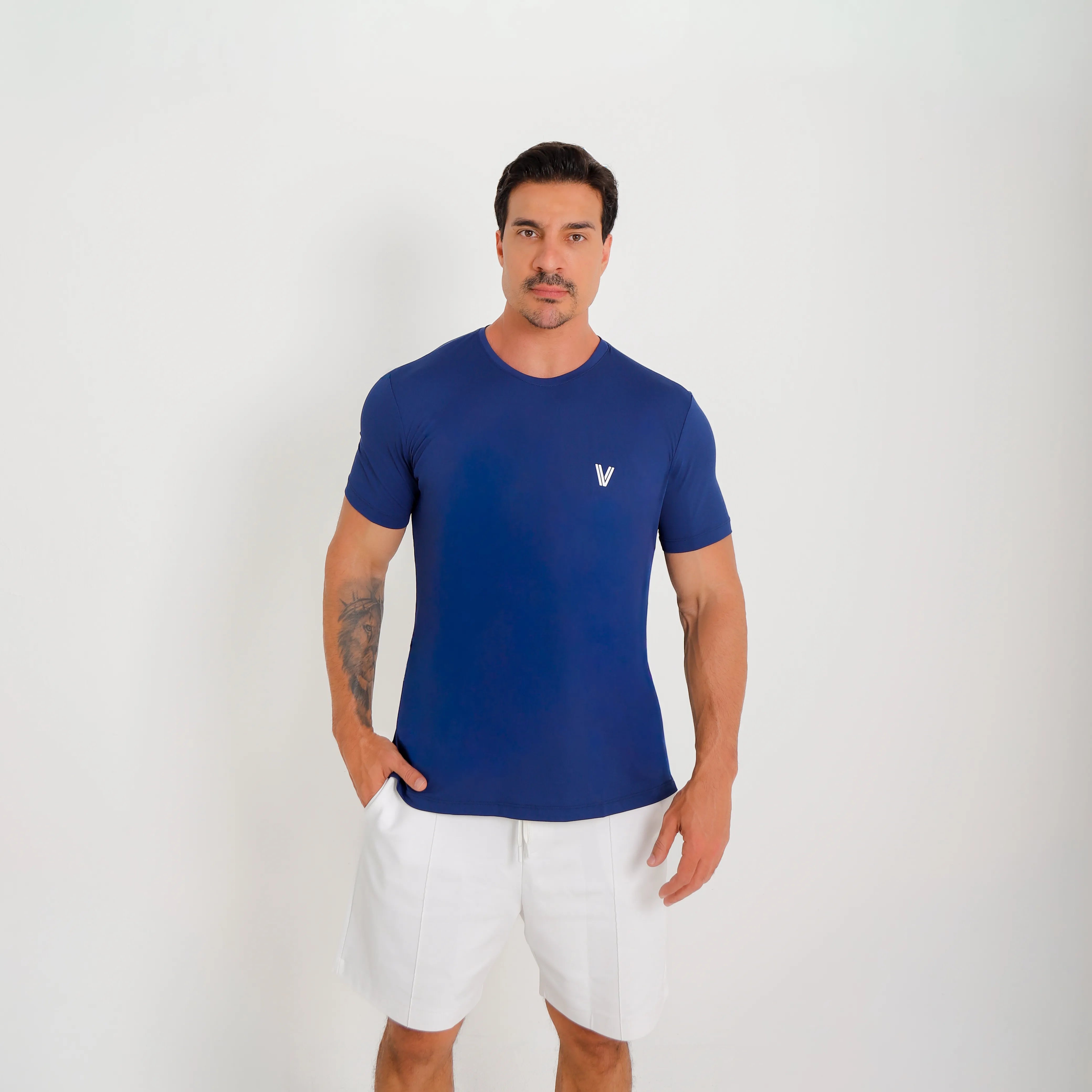 Camiseta de poliamida azul — logo Vistorr no peito — mãos soltas, olhar para a câmera, logo legível