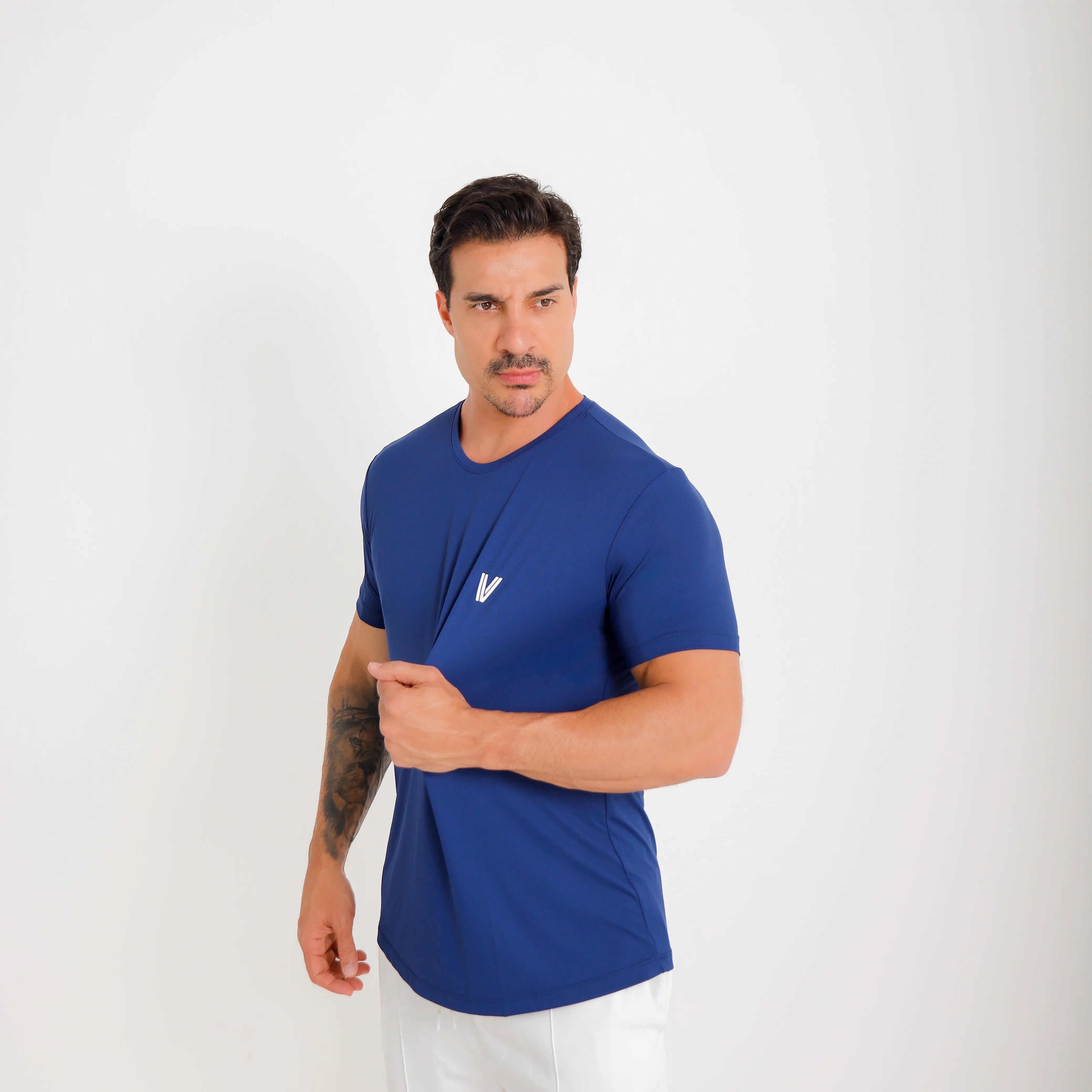 Camiseta de poliamida azul — logo Vistorr no peito — mãos soltas, olhar à esquerda