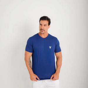 Camiseta de poliamida azul — logo Vistorr no peito — mãos soltas, olhar à esquerda, logo legível