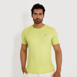 Camiseta de poliamida verde — logo Vistorr no peito — mãos soltas — olhar para a câmera — logo legível
