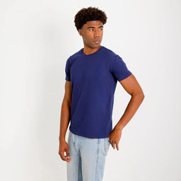 Camiseta Basica Algodao Egipcio azul-marinho, ângulo 3/4; tecido liso, ajuste confortável e barra levemente arredondada.
