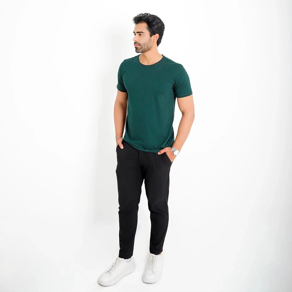 Camiseta Basica Algodao Egipcio verde-escuro, corpo inteiro; combinação casual com calça preta e tênis branco.