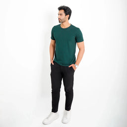 Camiseta Basica Algodao Egipcio verde-escuro, corpo inteiro; combinação casual com calça preta e tênis branco.