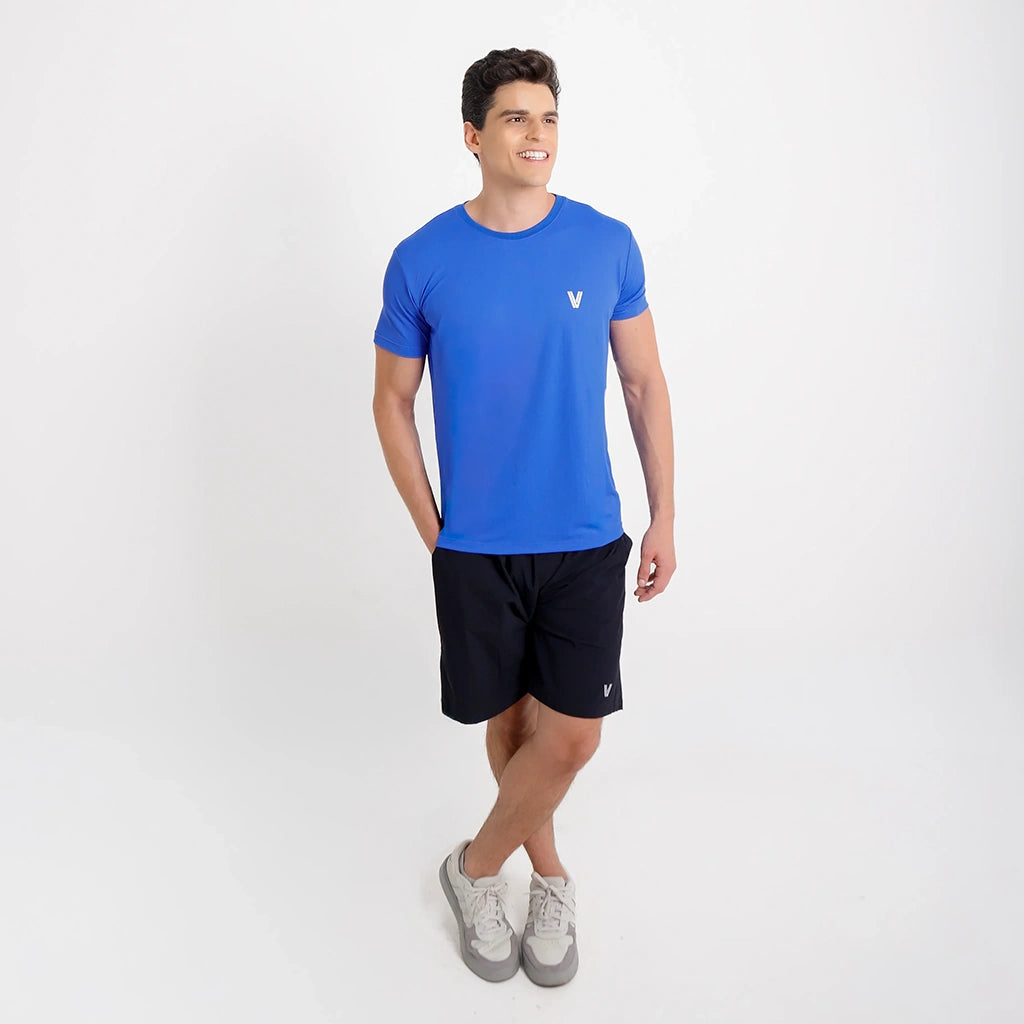 Camisetas Poliamida Esportiva azul escuro, look completo com short preto, em estúdio.