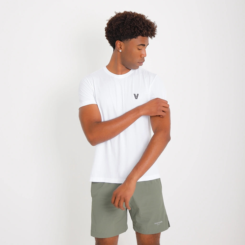 Camisetas Poliamida Esportiva branca, ângulo 3/4; modelo ajusta a manga, destacando caimento leve e gola careca.