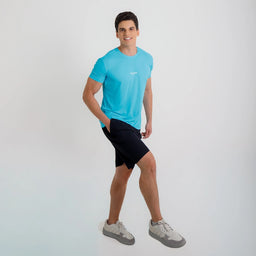 Modelo em posição de caminhada usando Camisetas Poliamida UV30 azul claro, short preto e tênis claros.