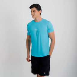 Modelo sorrindo em ângulo usando Camisetas Poliamida UV30 azul claro e short preto.