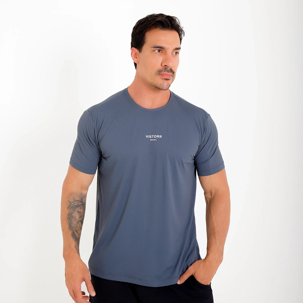 Camisetas Poliamida UV30 cinza, vista frontal 3/4; logo central pequeno e acabamento limpo.