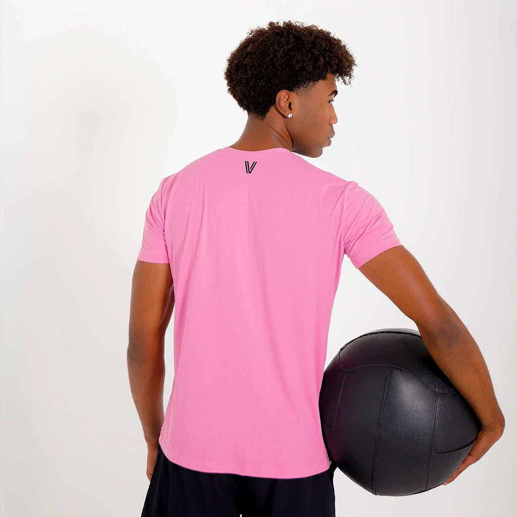 Costas da Camisetas Poliamida UV30 rosa claro, com o modelo segurando bola de exercício preta.