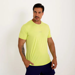 Camisetas Poliamida UV30 verde claro, vista de frente em fundo branco, com uma mão no bolso.