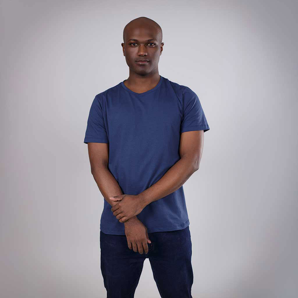 Homem de frente com camiseta azul vestindo calça jeans.