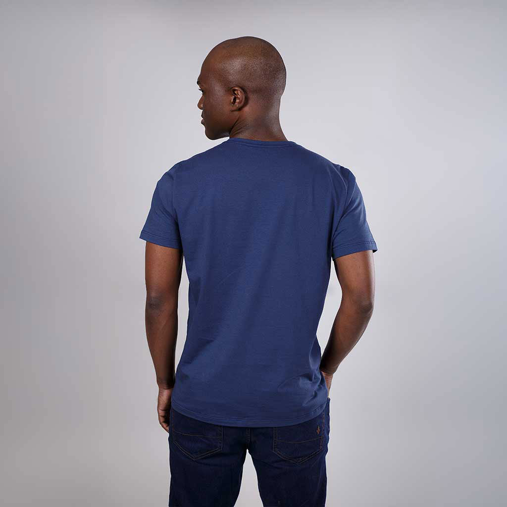 Homem de costas vestindo camiseta azul de algodão egípcio.