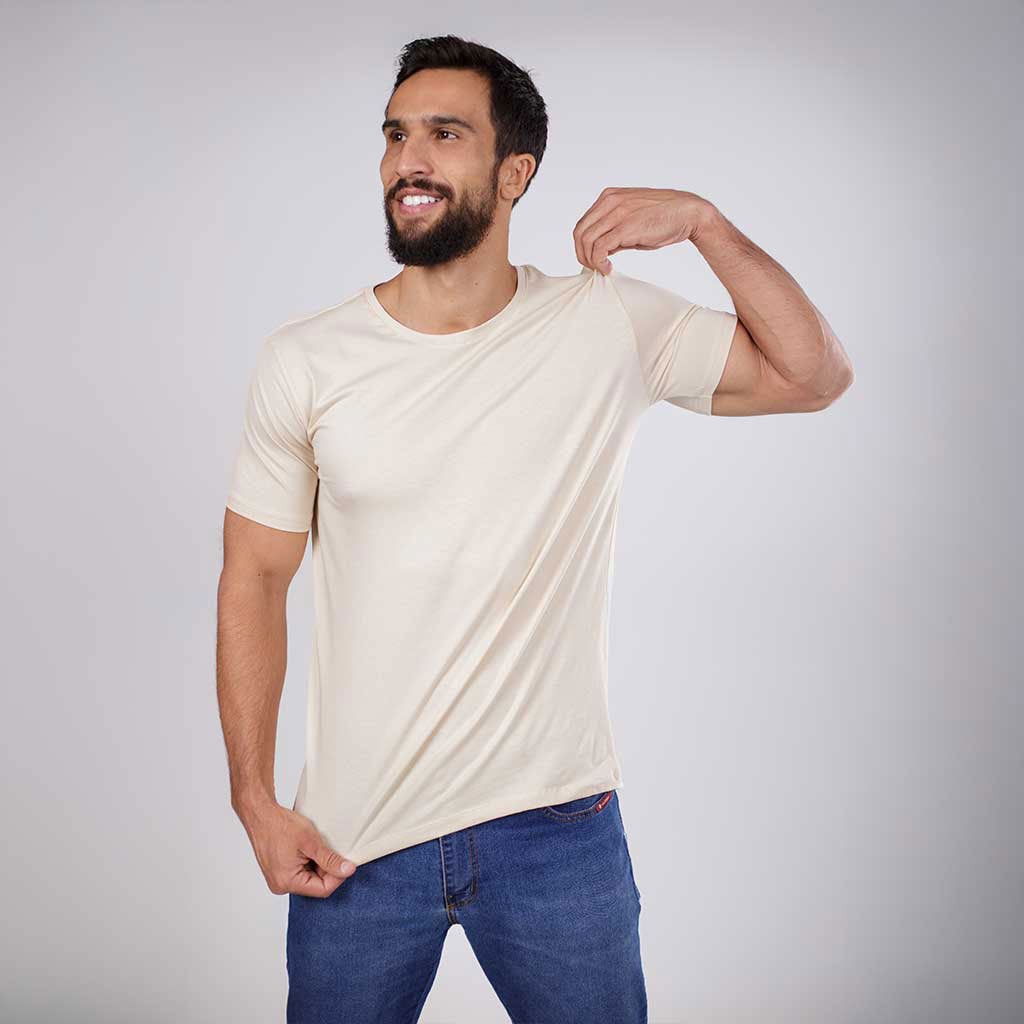 Homem sorrindo em ângulo inclinado vestindo camiseta crua.