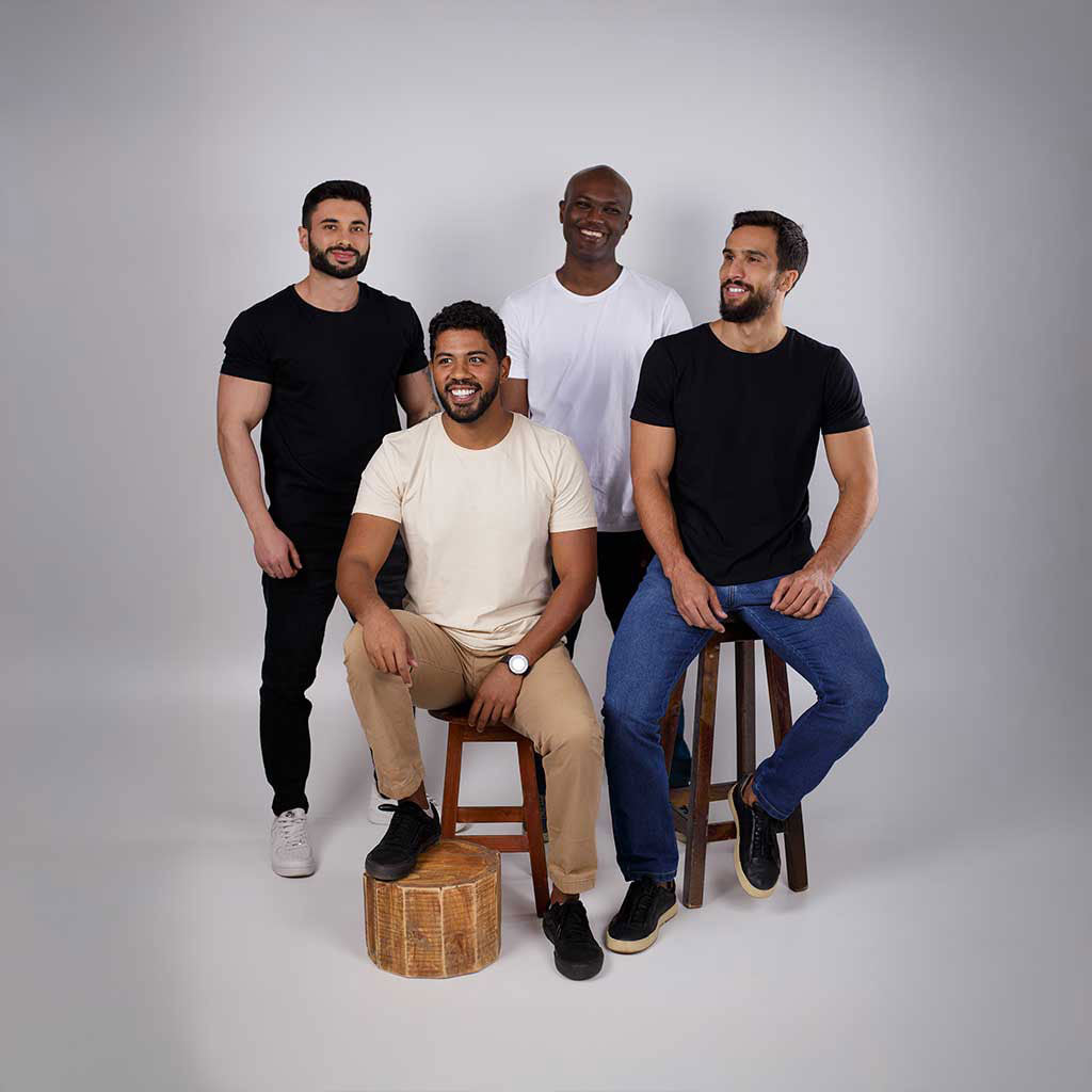 Homem sentado de frente usando camiseta de algodão casual.