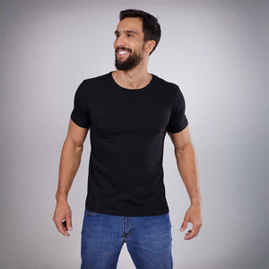 Homem sorrindo de frente vestindo camiseta preta e jeans.