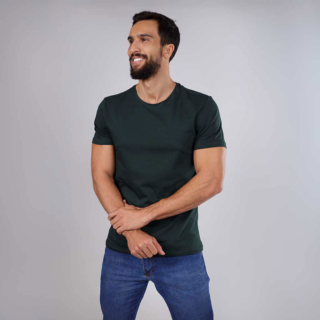 Homem sorrindo de frente vestindo camiseta verde escura.