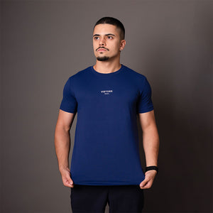 Modelo vestindo camiseta poliamida masculina azul Vistorr com logo centralizado no peito, em pose frontal.