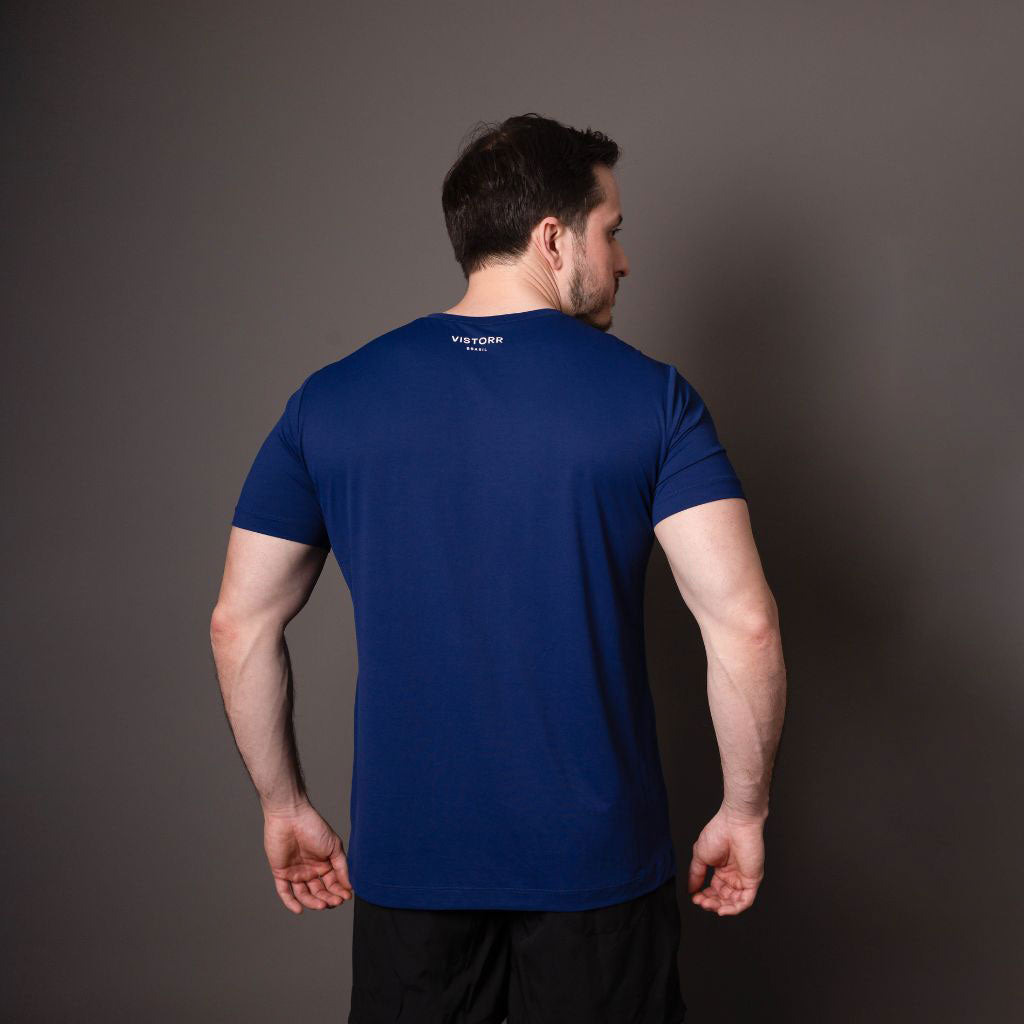 Homem de costas mostrando logo na camiseta azul de poliamida.