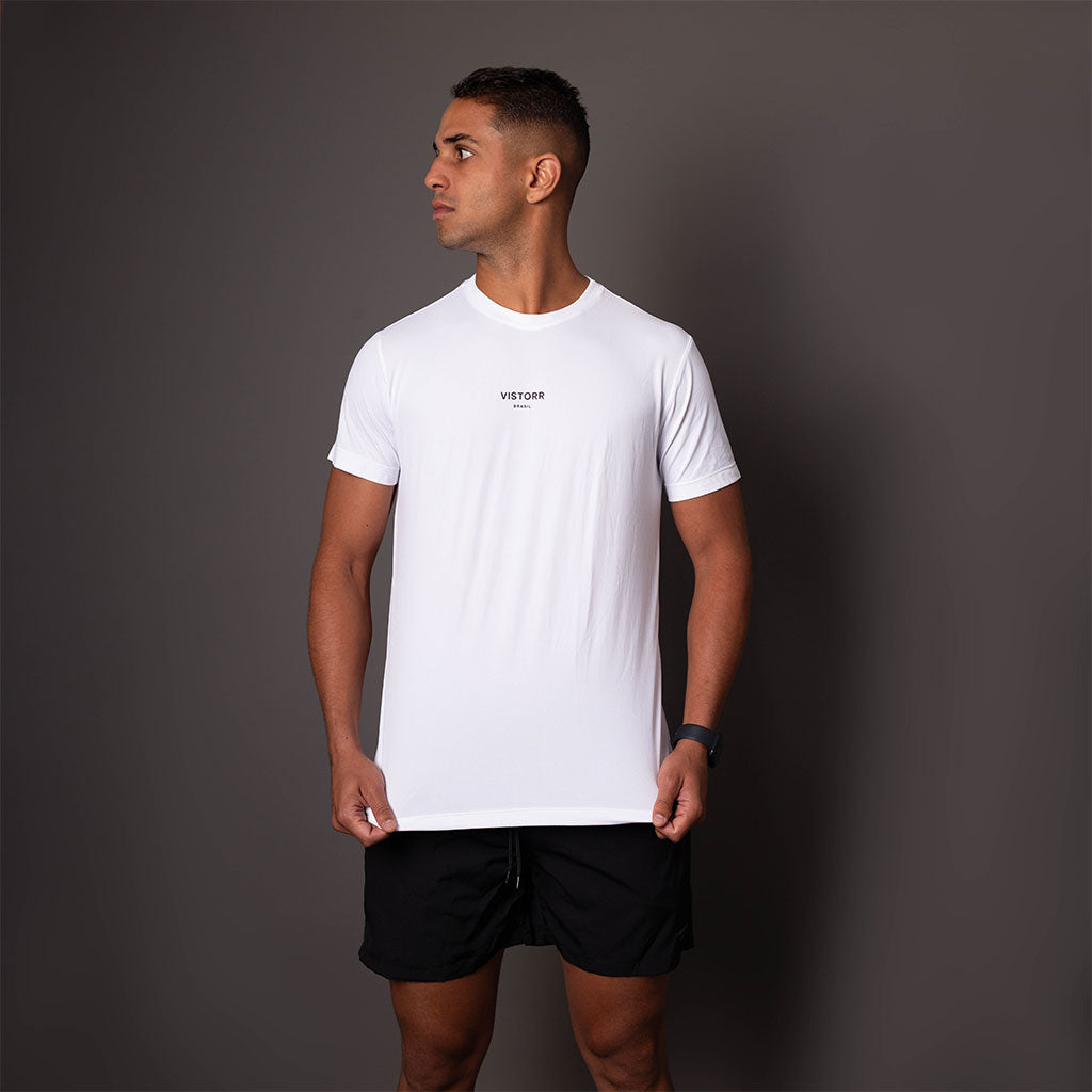 Modelo usando a camiseta branca em poliamida masculina Vistorr de frente. 