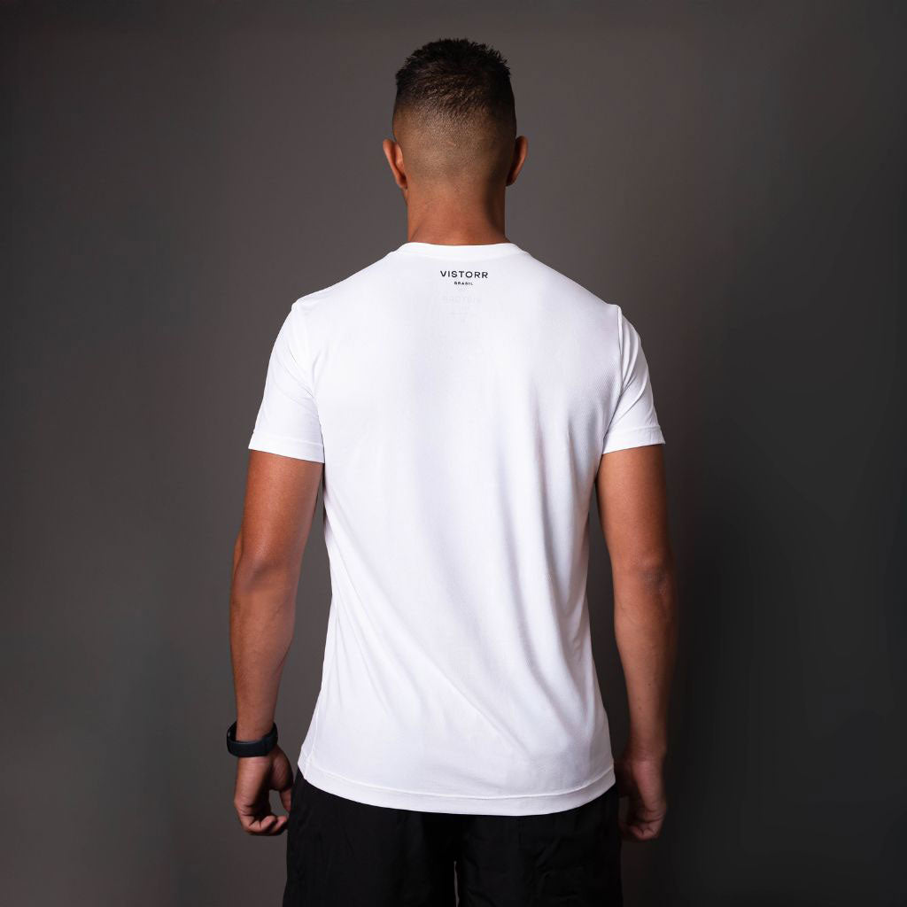 Homem de costas vestindo camiseta branca com logo Vistorr.