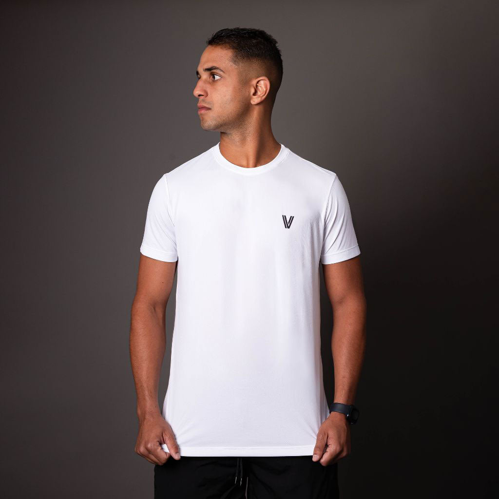 Modelo usando camiseta branca em poliamida Vistorr masculina com logo discreto, ideal para treino ou casual. 