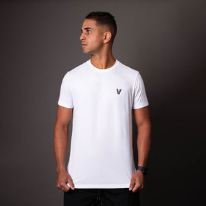 Modelo usando camiseta branca em poliamida Vistorr masculina com logo discreto, ideal para treino ou casual. 