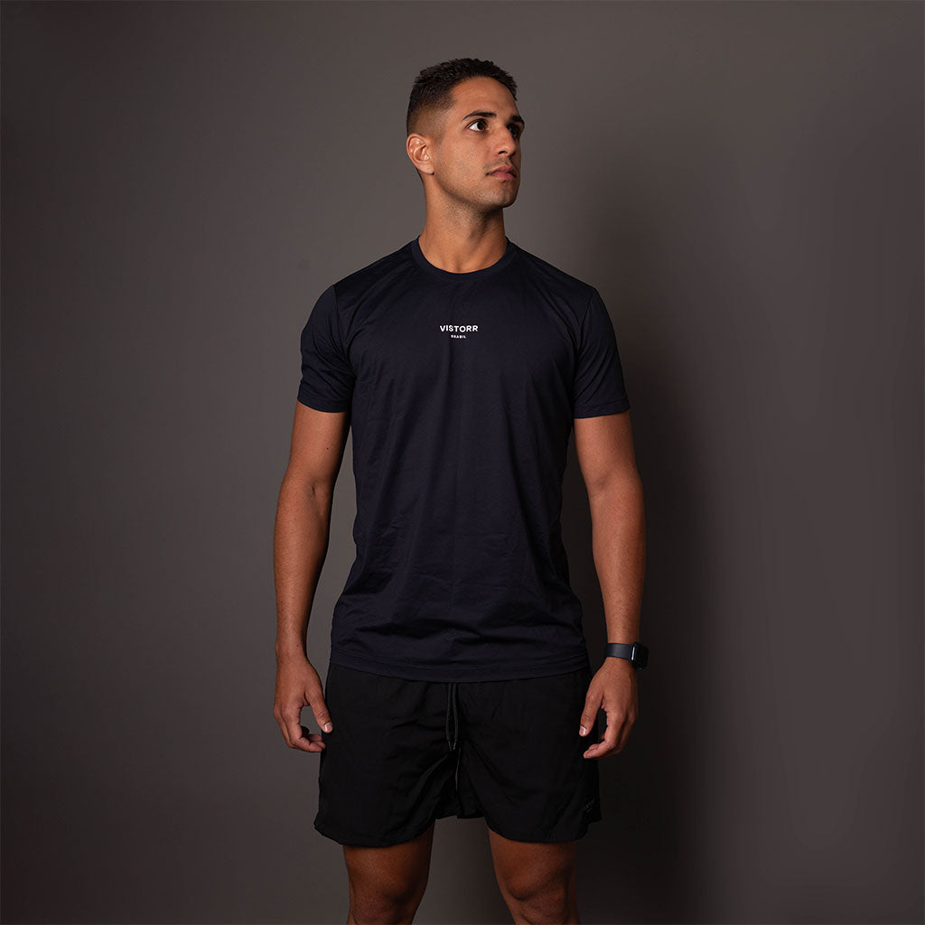 Modelo usando a camiseta poliamida masculina preta Vistorr com logo VISTORR BRASIL.