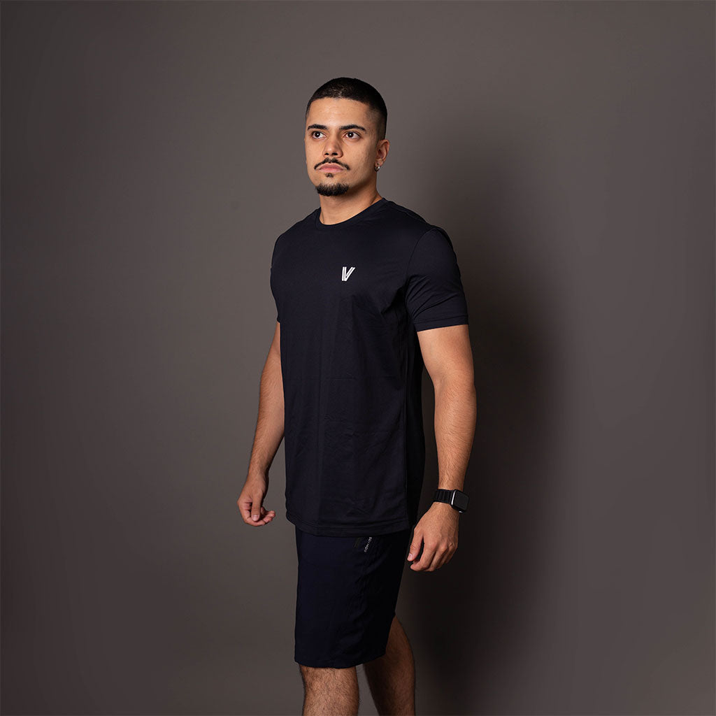 Modelo de lado usando a camiseta masculina preta em poliamida Vistorr com estampa discreta do logo no alto. 