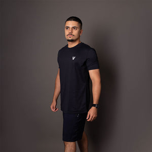 Modelo de lado usando a camiseta masculina preta em poliamida Vistorr com estampa discreta do logo no alto. 