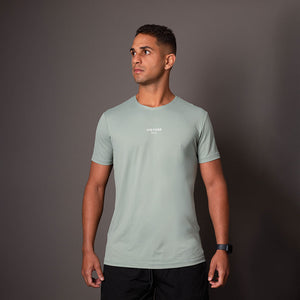 Modelo vestindo camiseta poliamida Verde Musgo masculina Vistorr com estampa no centro do peito