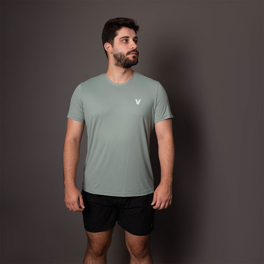 Modelo usando a camiseta verde masculina Vistorr V com caimento ajustado de frente.