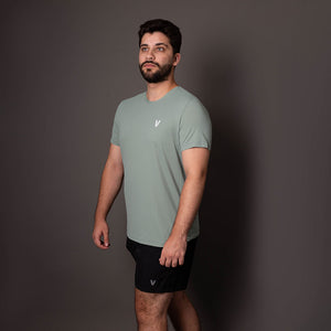 Modelo usando a camiseta verde masculina Vistorr V com caimento ajustado de lado.