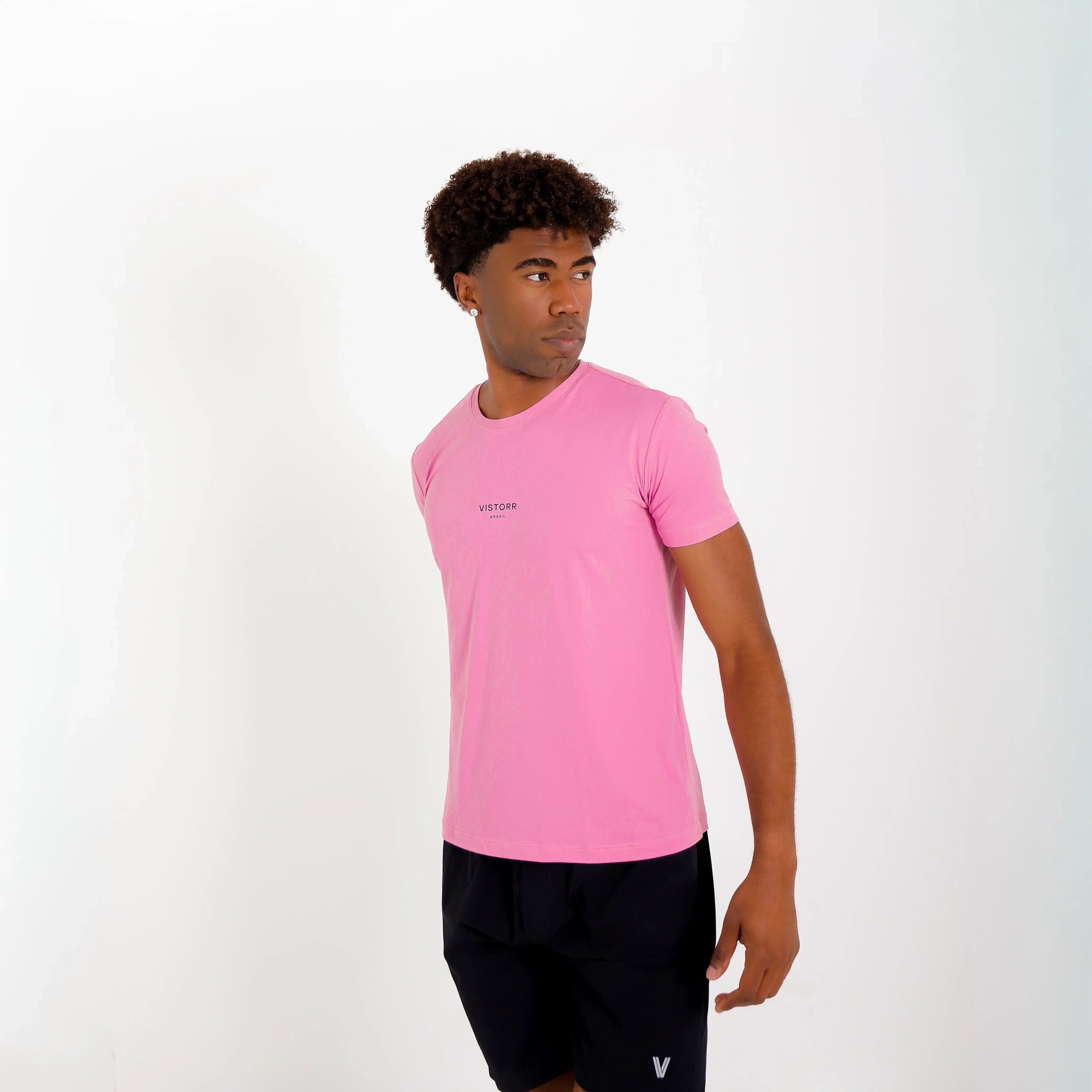 Camiseta de poliamida rosa — logo Vistorr Brasil — mãos soltas, olhar para a câmera, logo legível