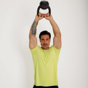 Camiseta de poliamida verde — logo Vistorr Brasil — mãos soltas | olhar à esquerda | logo legível