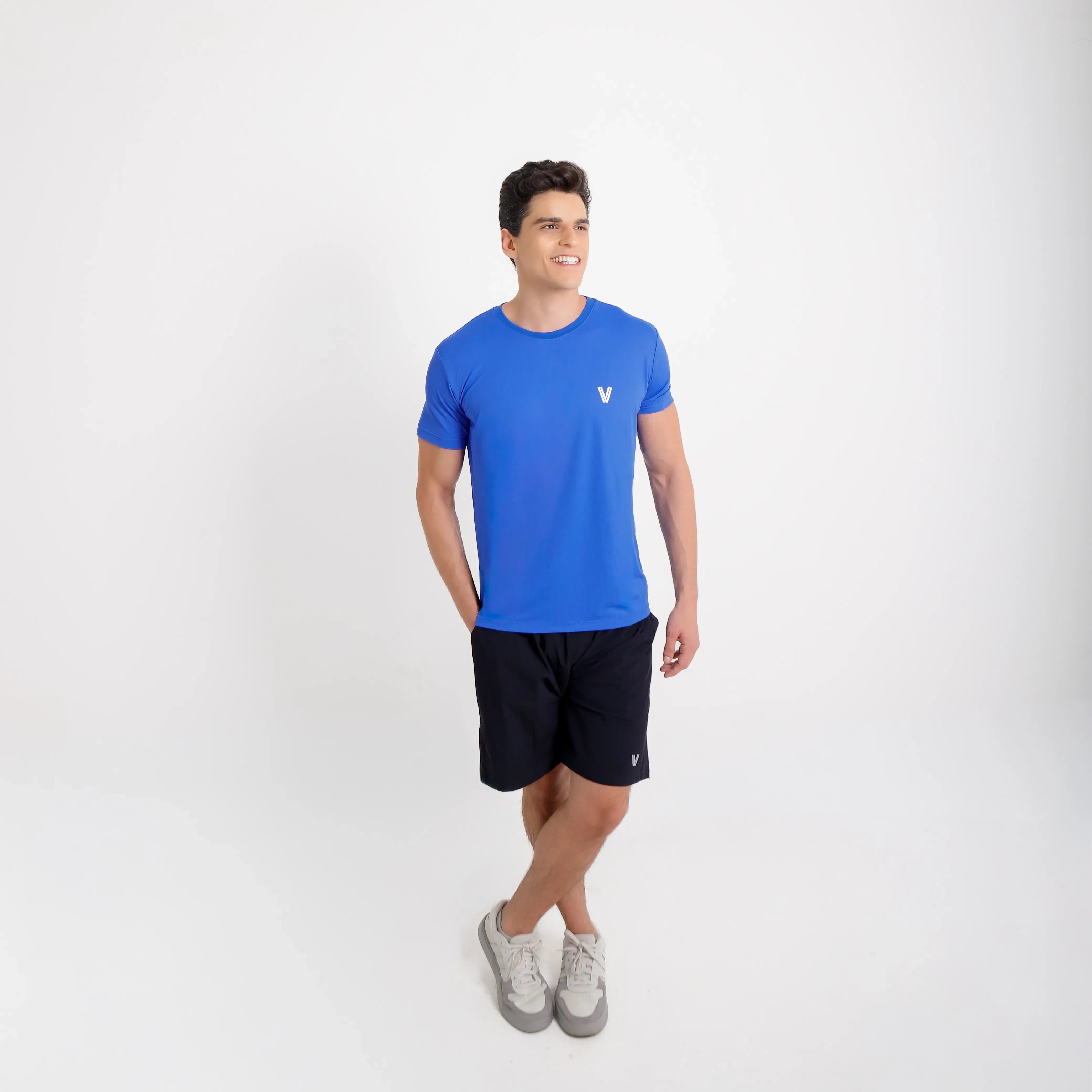 Camiseta de poliamida azul — logo Vistorr no peito — mãos soltas, olhar à esquerda