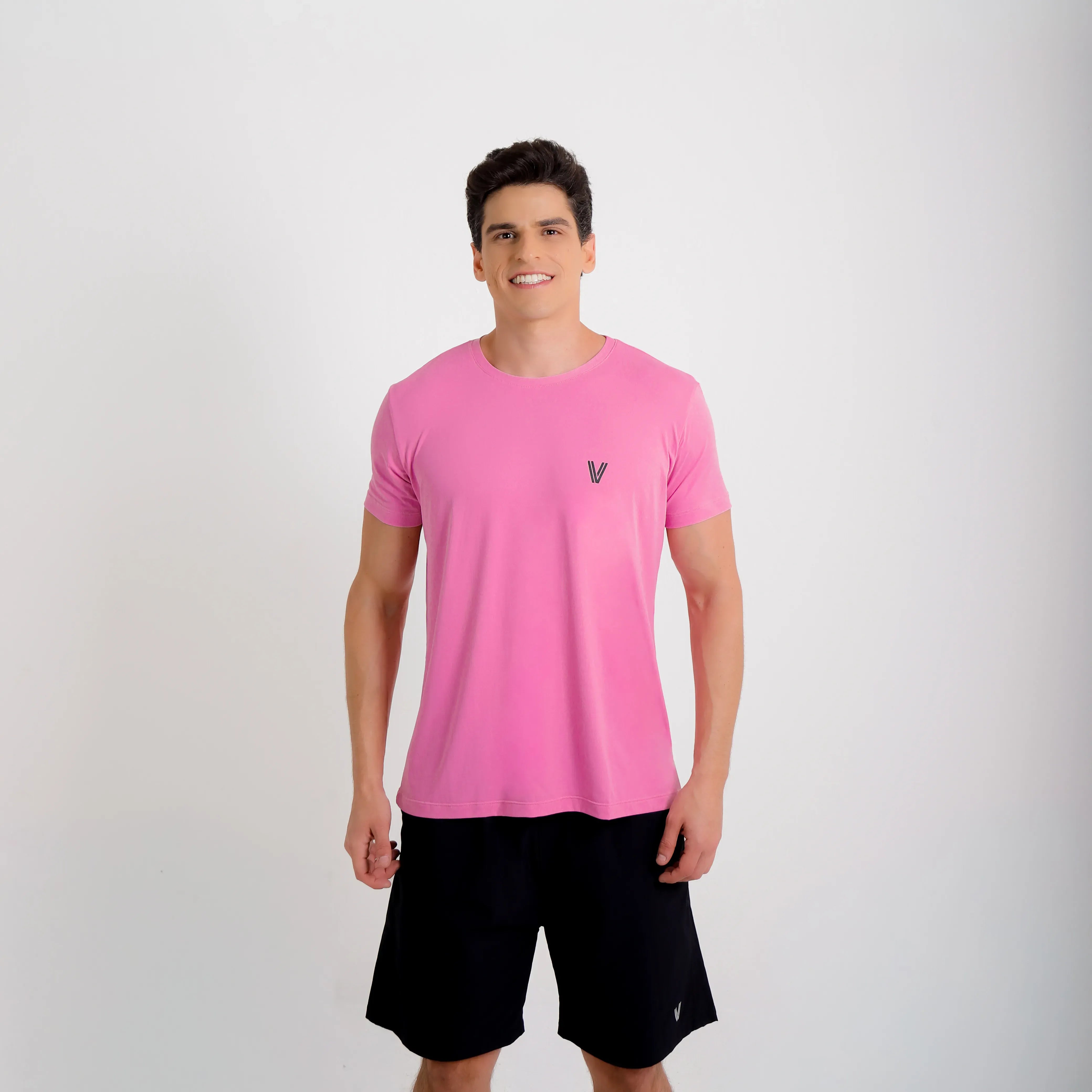 Camiseta de poliamida rosa — logo Vistorr no peito — mãos soltas, olhar à esquerda, logo legível