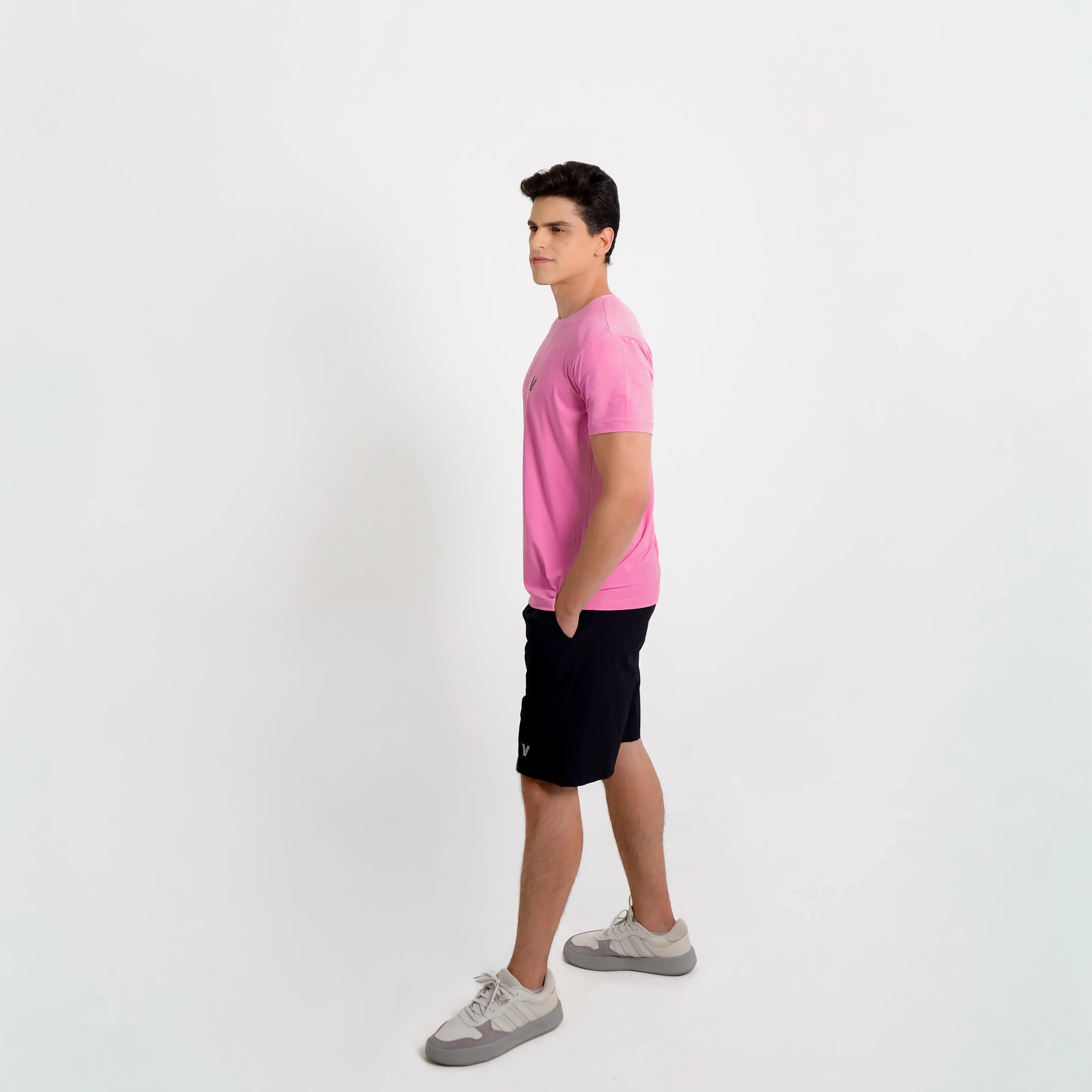 Camiseta de poliamida rosa — logo Vistorr no peito — mãos soltas — olhar para a câmera — logo legível