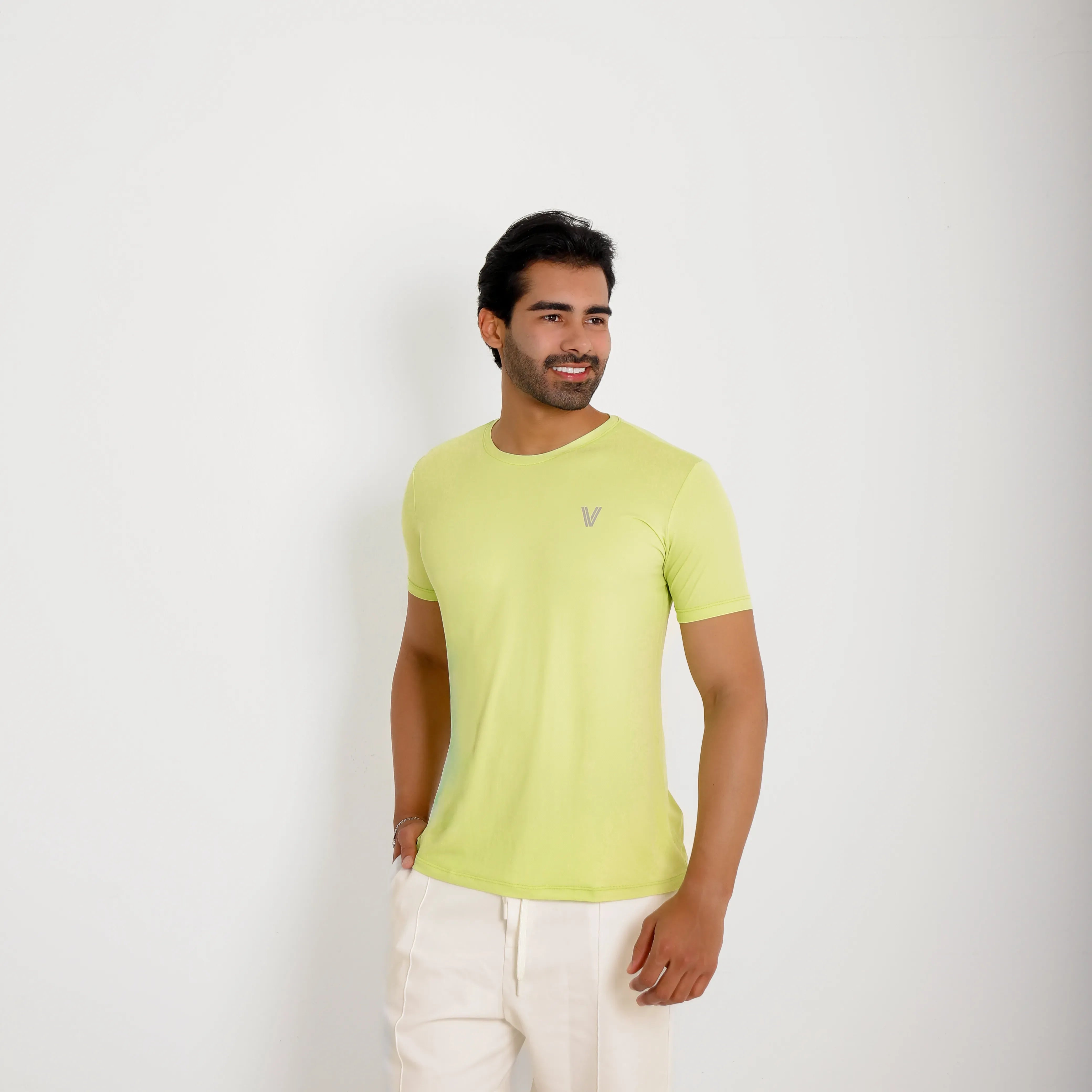 Camiseta de poliamida verde — vista lateral — mãos soltas, olhar à esquerda