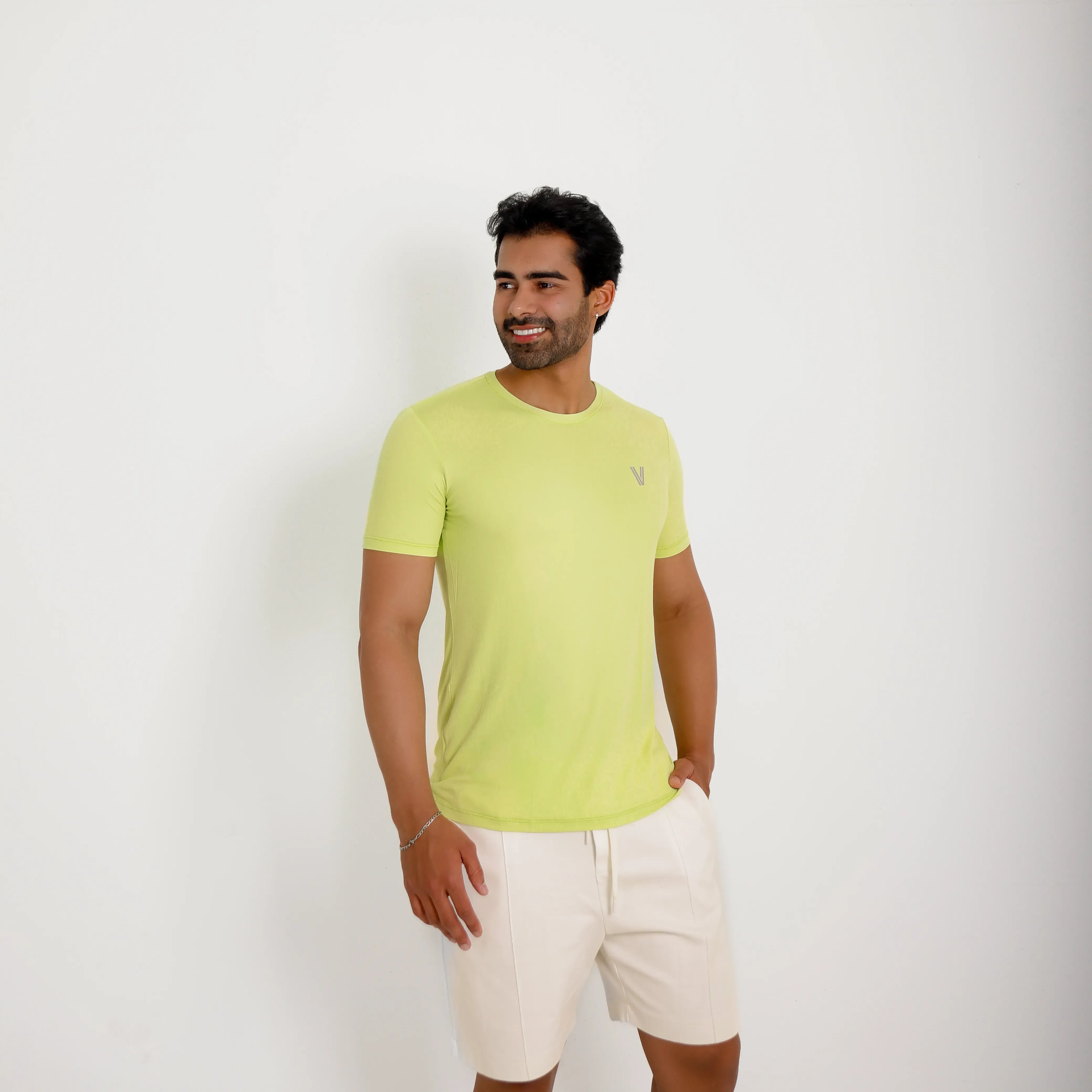 Camiseta de poliamida verde — vista lateral — mãos soltas, olhar à esquerda